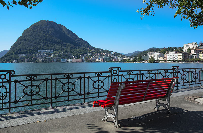 Eine rote Bank steht am Luganer See